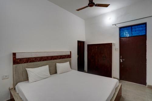 加济阿巴德OYO Sky Line的卧室配有白色的床和吊扇