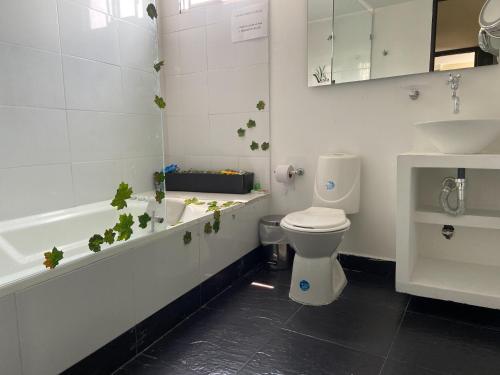 内瓦Hotel Vesta Boutique的浴室设有卫生间和植物浴缸。