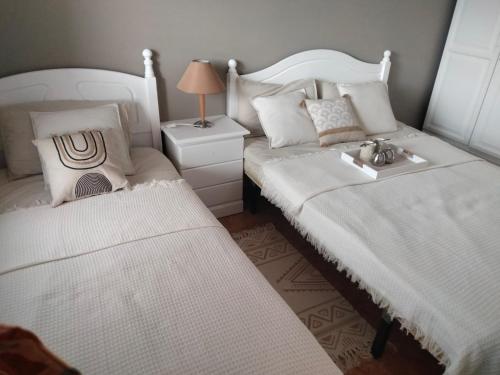 卡勒达德福斯特Diamante de la Bahia的一间卧室设有两张床和一张桌子上的台灯。