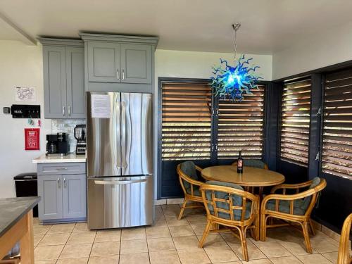 蒙内罗亚Kepuhi Sunset Ocean View - Ground Floor Unit by Wrinkly Sheets, LLC的厨房配有桌椅和冰箱。