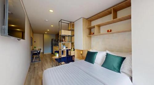 波哥大Apartasuites Cabrera 85的卧室配有带绿色枕头的大型白色床