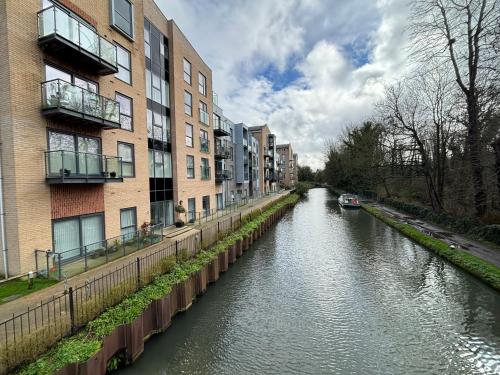 赫默尔亨普斯特德Luxury Canal-side Apartment, Hemel Hempstead, Free parking, Perfect for Contractors的一条河,在建筑物旁边有船