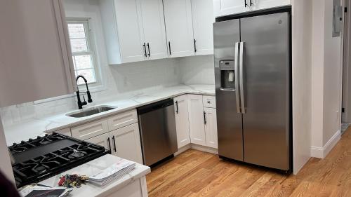 Cedar Manorjfk 5 min away的厨房配有不锈钢冰箱和白色橱柜