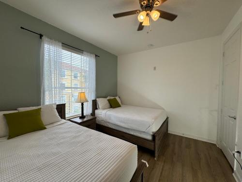 奥兰多Vista Cay Getaway Luxury Condo by Universal Orlando Rental的一间卧室配有两张床和吊扇