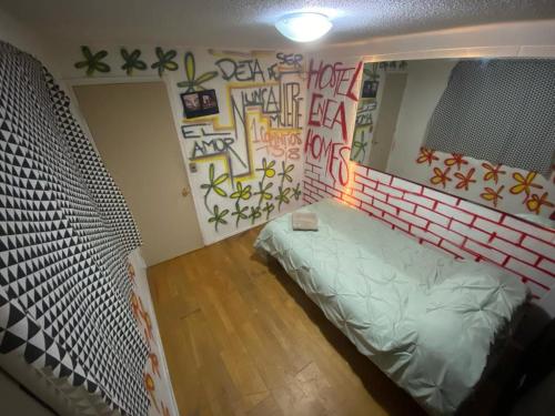 圣地亚哥Hostel Enea Homes的一间设有床铺的客房,墙上涂鸦