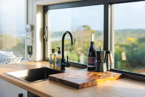 CurrieTiny Rupetta的带水槽、瓶装葡萄酒的厨房台和窗户