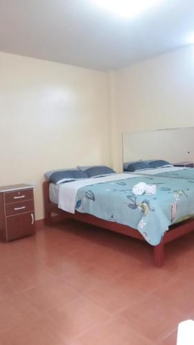 阿亚库乔Hospedaje PARAÍSO的一间卧室配有一张带蓝色棉被的床