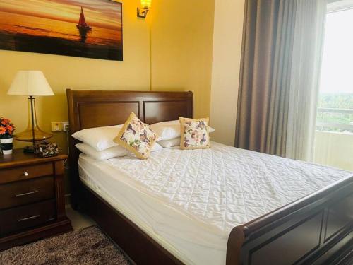 PannipitiyaRental Apartment in Kottawa的卧室配有带枕头的床铺和窗户。