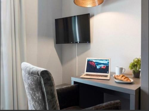 加勒穆恩Studio Apartment Oslo AirPort的一张桌子,上面有一台笔记本电脑和一盘食物