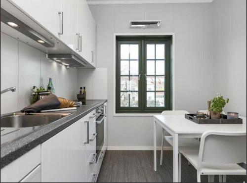 加勒穆恩Studio Apartment Oslo AirPort的白色的厨房,配有桌子和窗户