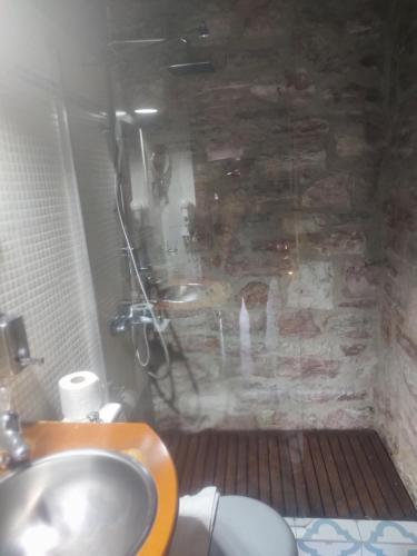 卡尔派尼西翁Petrino Rodo的一间带水槽和石墙的浴室