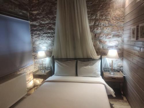 卡尔派尼西翁Petrino Rodo的一间卧室配有一张带2个床头柜和2盏灯的床。