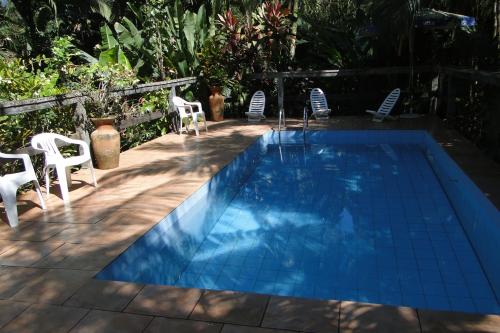 莫雷蒂斯Pousada do Oasis的一个带白色椅子和桌子的游泳池