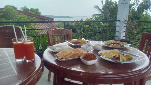 阿努拉德普勒Lake Edge Resort的阳台上的桌子上摆放着食物和饮料