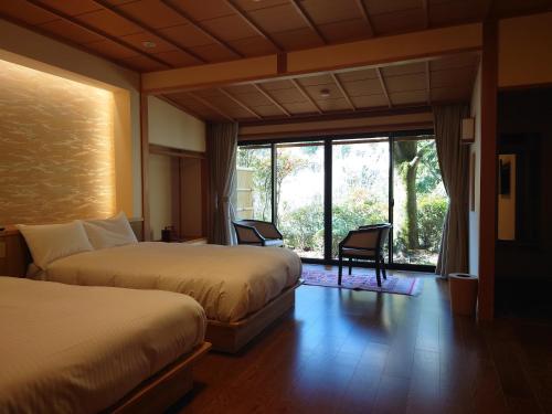 下吕市卡瓦卡米亚旅馆的酒店客房设有两张床和大窗户。
