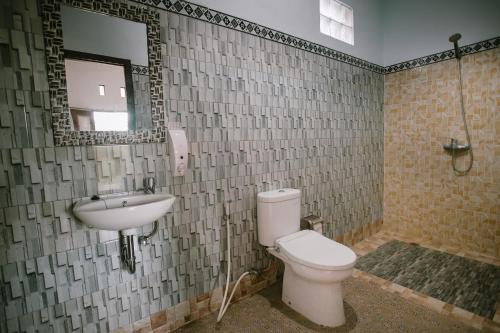 珀尼达岛De Casa Ananda Nusa Penida的一间带卫生间、水槽和镜子的浴室
