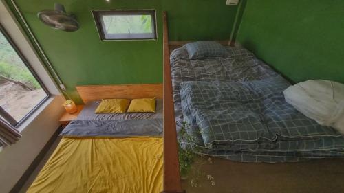 木州县Vườn Trên Mây - Skyline Farm & Homestay的绿墙客房的两张床
