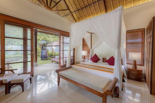 金巴兰Villa Dorado - Steps from Jimbaran Beach的一间卧室配有一张带天蓬的床