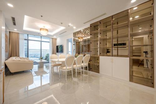 胡志明市Landmark 81 SHA PLUS Residence的一间厨房,配有白色橱柜和一间餐厅