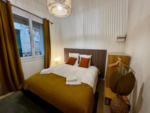 卡西斯LE PETIT PECHEUR DE CASSIS的一间卧室配有带橙色枕头的床和窗户。