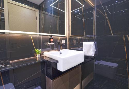 迪拜EasyGo - Binghatti Luna Stylish 1BR的浴室设有白色水槽和黑色瓷砖