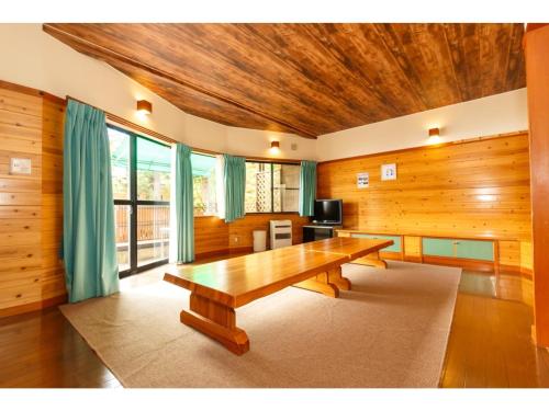 大石Lake Kawaguchi Rental Villa Tozawa Center - Vacation STAY 46845v的一间带木桌和电视的用餐室