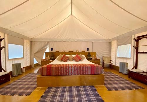 斋沙默尔Desert Camps Heritage Jaisalmer的帐篷内一间卧室,配有一张床