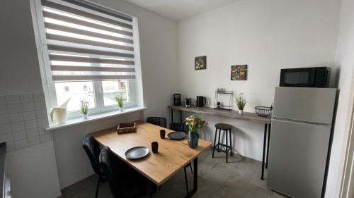 莱比锡Charmante Wohnung in der Südvorstadt的厨房配有木桌和冰箱。