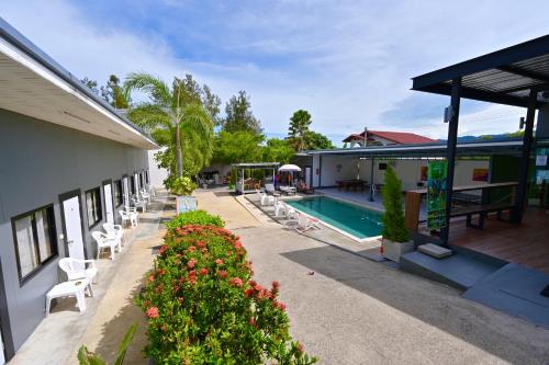 班拉克海滩苏梅岛背包客旅馆的一个带游泳池和椅子的度假胜地和一座建筑