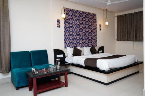 SatnaHotel Mahamaya的一间卧室配有一张床、一张沙发和一张桌子