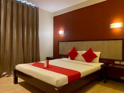 马尼拉Asiatel Airport Hotel的一间卧室配有一张带红色枕头的大床
