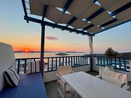 伊拉克利亚岛Villa Meltemi的阳台配有桌椅,享有日落美景。