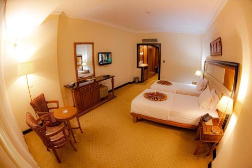 开罗paradise hotel的大型酒店客房,配有一张床和一张书桌