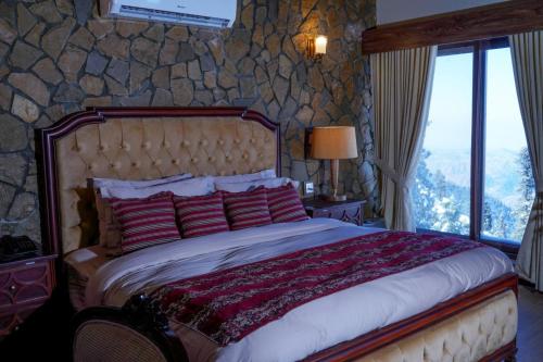Chhāngla GaliCedar Lodges Resort and Residences Galiyat的一间卧室设有一张带石墙的大床