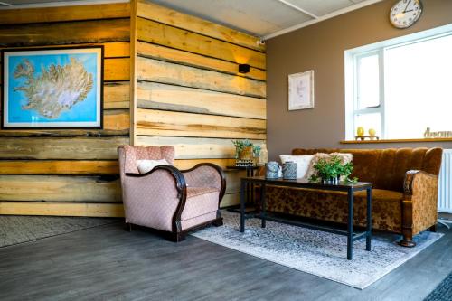 阿克雷里Akureyri Hostel的客厅配有两把椅子和一张桌子