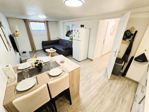 皮耶尔莱Appartement T2 confortable的厨房以及带桌椅的起居室。