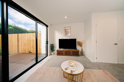 Charming Retreat in the Heart of Christchurch City-CBD的一间带电视和大窗户的客厅