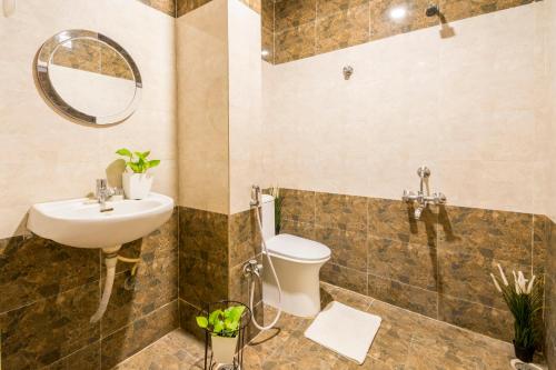 海得拉巴Hotel Fortune Hyderabad Airport Zone的一间带水槽、卫生间和镜子的浴室