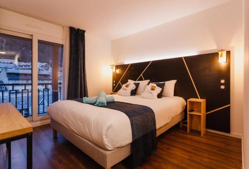 科特雷Garden & City Cauterets Balneo的酒店客房设有一张大床和一个阳台。