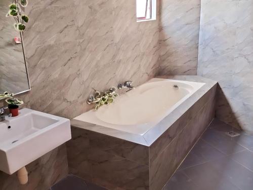 吉隆坡RPC Blissful Homes & Hotel的浴室配有白色浴缸和水槽