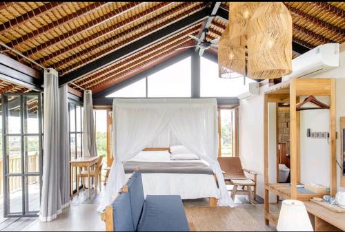 NgaglikBaku living villa的一间设有床铺的卧室,位于带窗户的房间内