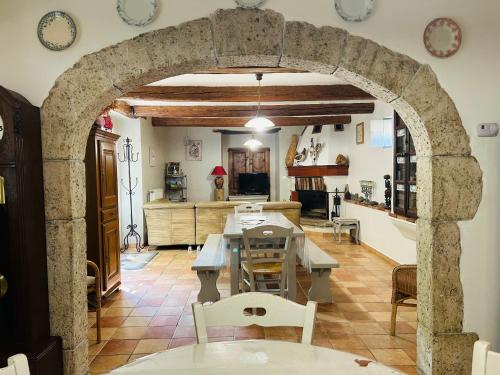 昂迪兹Les Gîtes et la Chambre de Labahou SPA的厨房以及带石拱门的用餐室