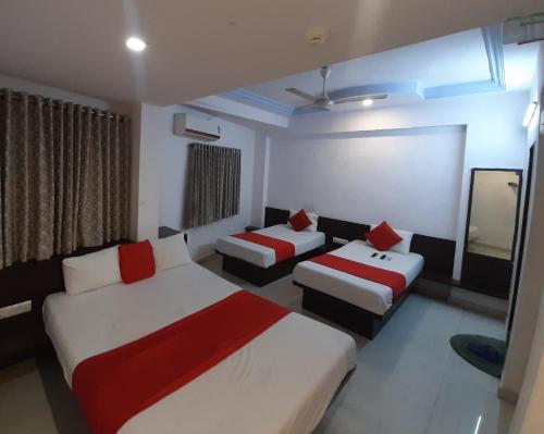 艾哈迈达巴德hotel royal night的酒店客房,设有两张床和一张沙发