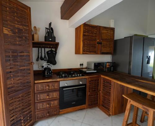 托弗海滩Casa do Índico的厨房配有木制橱柜和炉灶烤箱。