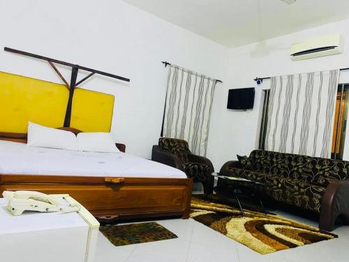 科托努AULNES RESIDENCE HOTEL的酒店客房,配有床和沙发