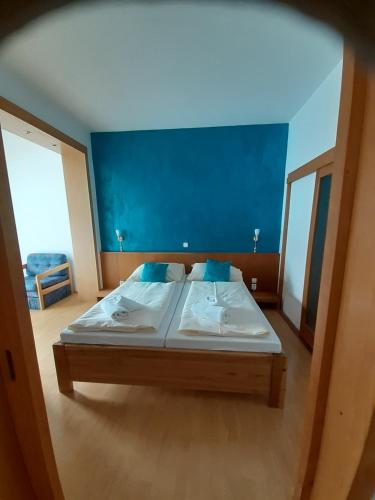 特尔乔夫Hotel Gold的一间卧室设有一张蓝色墙壁的大床