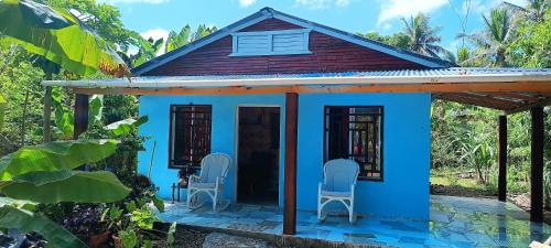 圣斐利-银港Casa de campo的前面有两把椅子的小蓝色房子
