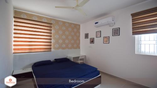 班加罗尔StayMazing Manyata-1BHK Boutique AC Apartments -Couple Friendly的一间卧室设有蓝色的床和窗户。