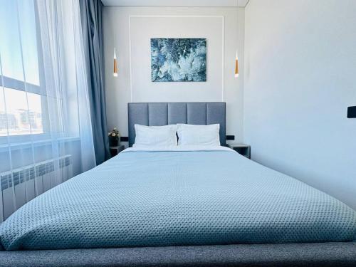 阿斯塔纳Кок Жайлау apartament的一间卧室配有一张带白色床单的大床