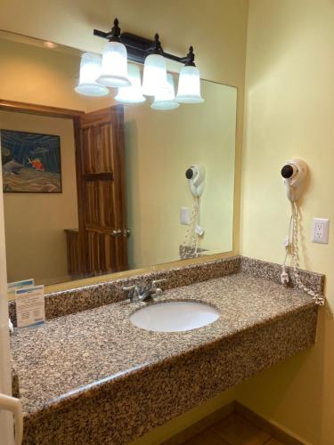特拉Honduras Shores Plantations的浴室的柜台设有水槽和镜子
